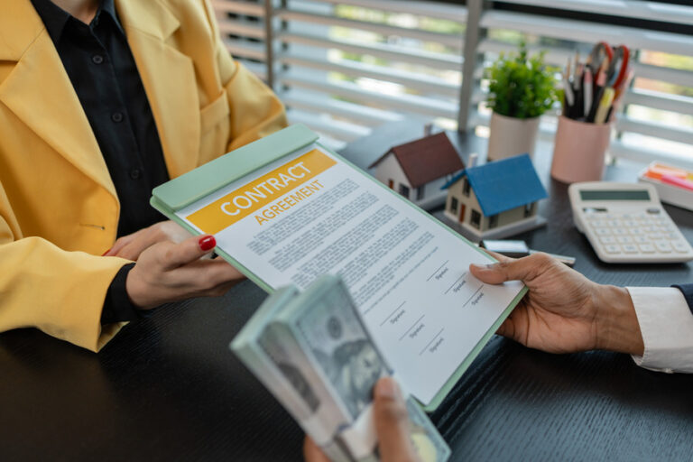 Deux personnes concluant un marché immobilier avec un contrat et des argents pour payer l'agence