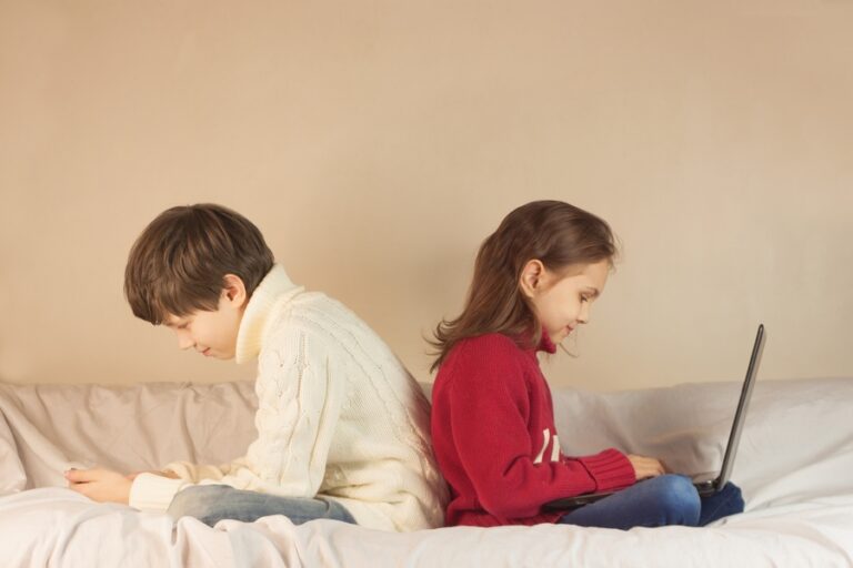 Le petit garçon et la petite fille jouent au gadget dans la même chambre