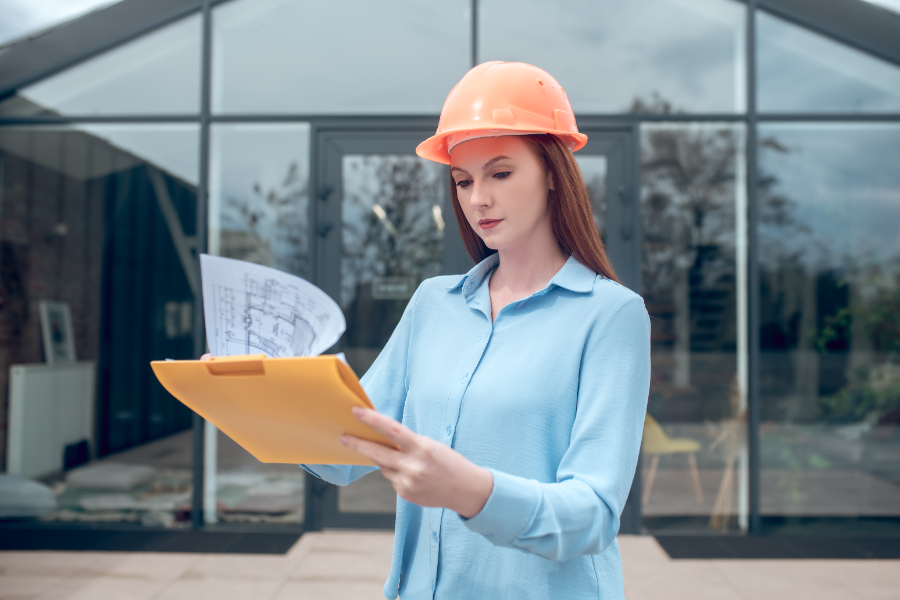 Une ingénieure de construction recevant des lettres venant du maire pour un non-respect du permis de construire 