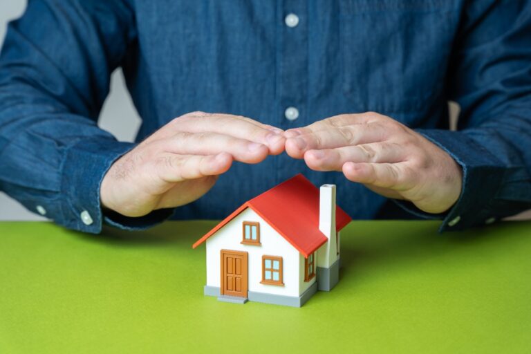 Des documents d’assurance habitation posés sur une table, avec clés du logement et stylo pour la signature