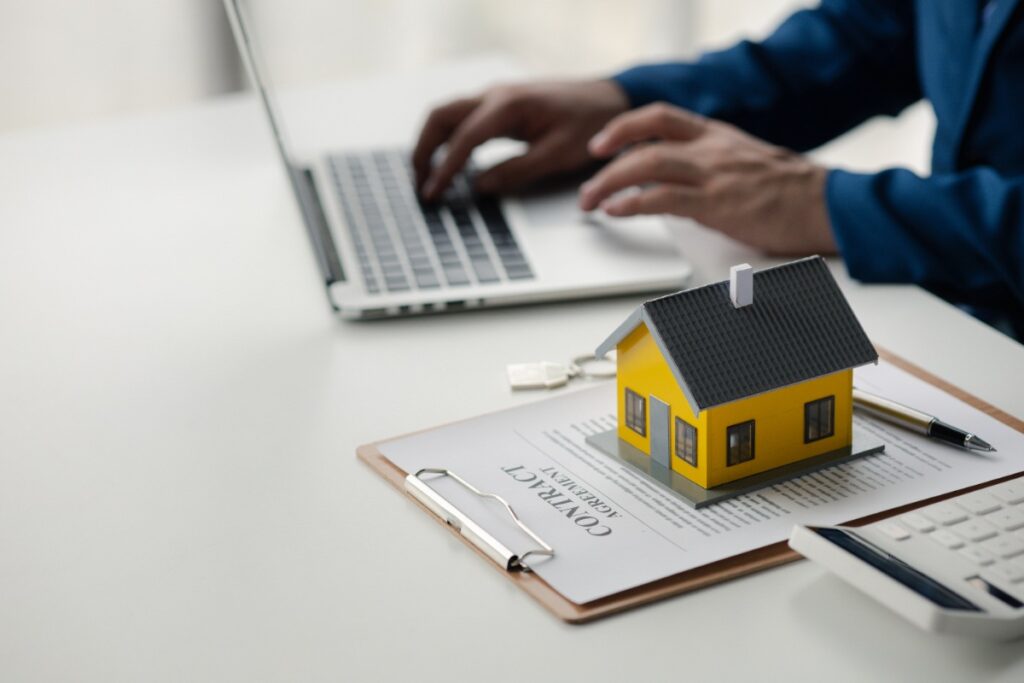 Une personne assise devant son ordinateur et l'utilise pour faire sa déclaration de biens