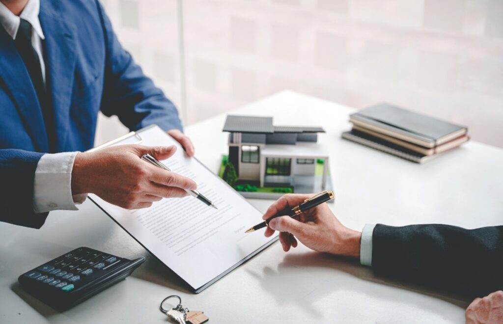 Un consultant en immobilier faisant signer un contrat à un client