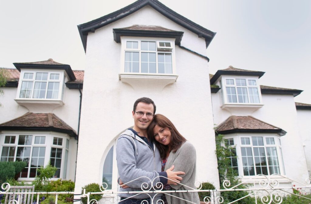 Un couple heureux devant leur nouvelle maison