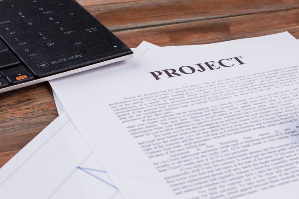Des papiers avec un projet placés devant un ordinateur
