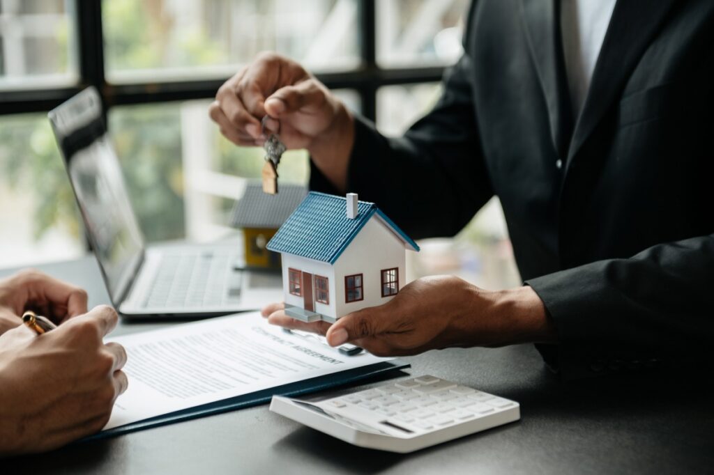 Un agent courtier immobilier donnant une clé à un client