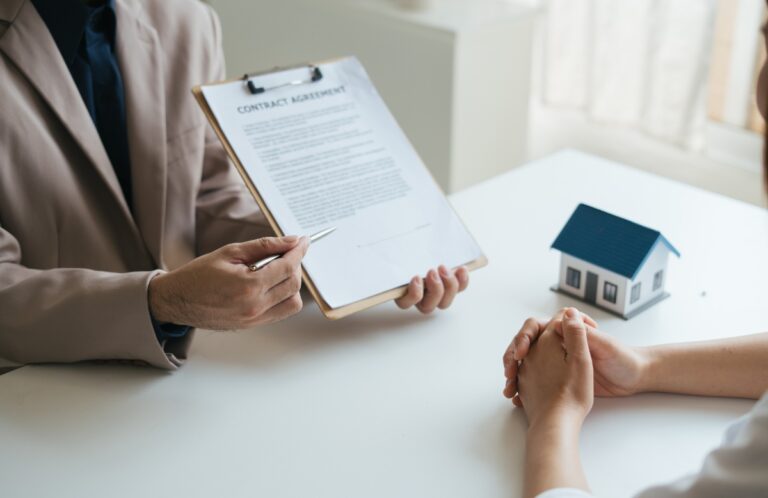 Un agent immobilier qui montre contrat à une personne