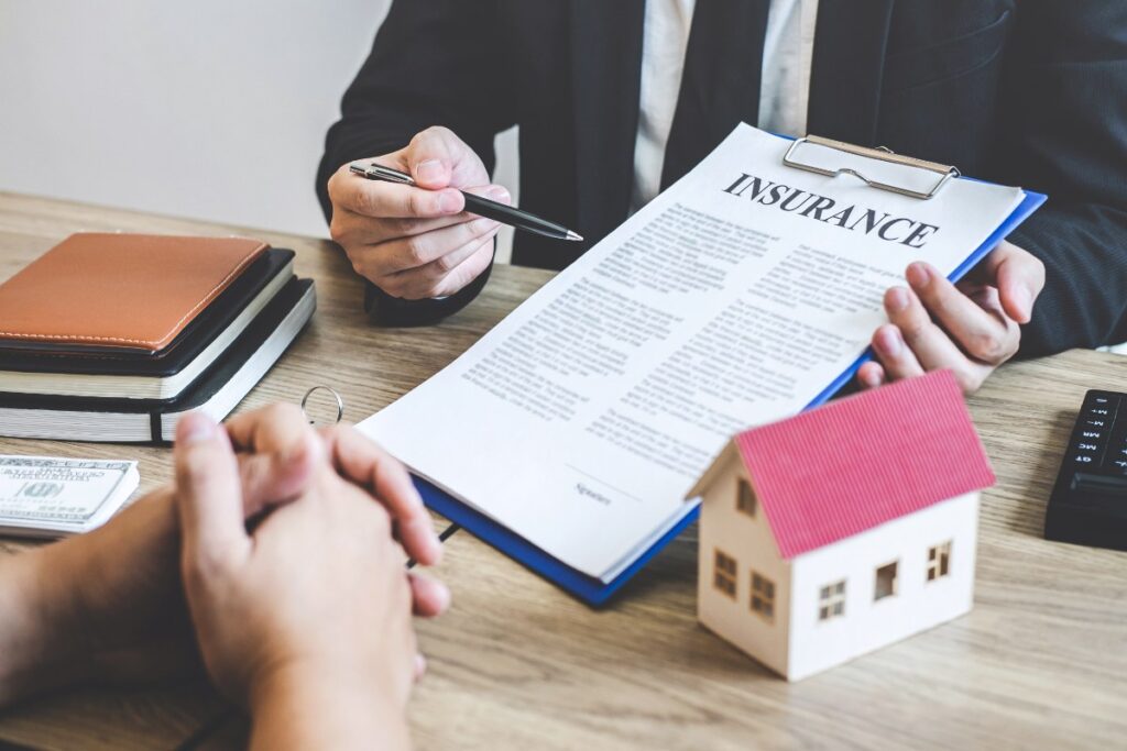 Un agent immobilier remettant le contrat d'assurance habitation à un client