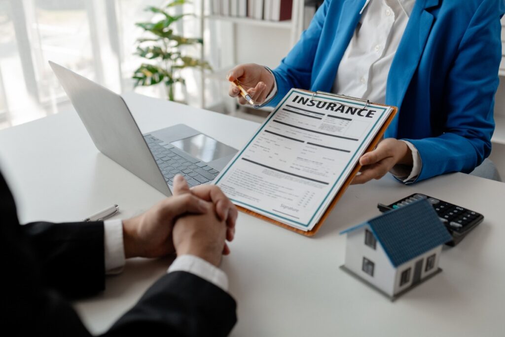 Un agent immobilier tenant des documents relatifs à l'assurance habitation