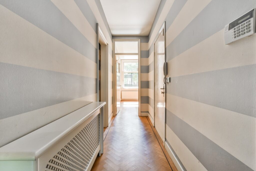 Un couloir entre des murs rayés avec une climatisation installée