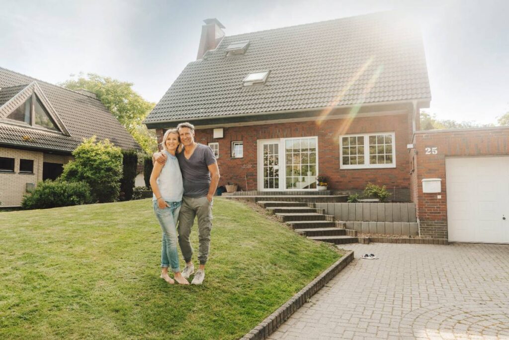 Un couple dans un jardin devant une maison