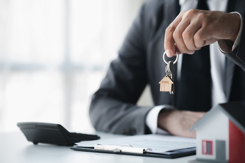Un homme tenant une clé à côté d'une maison