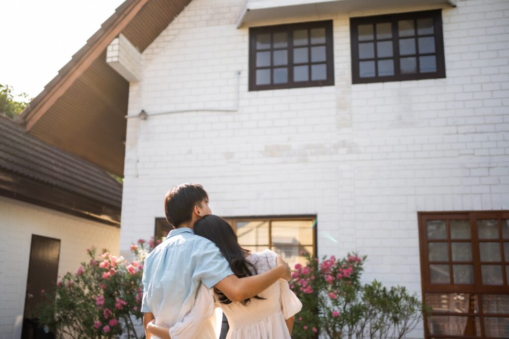 Un jeune marié heureux devant la maison