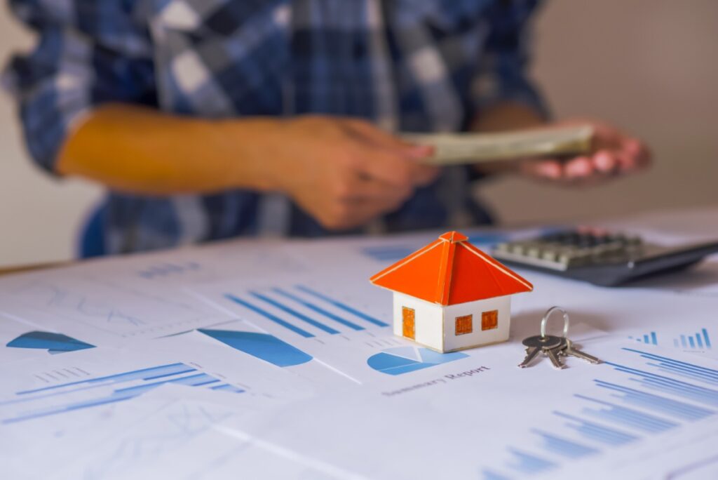 Une petite maison avec une clé et des papiers sur la table