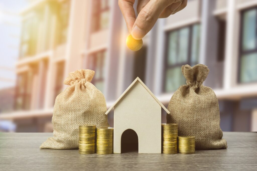 Une maison et des monnaies sur la table