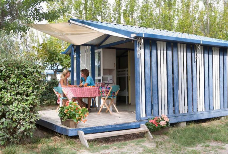 Un mobil-home installé avec des gens assisent autour d'une table