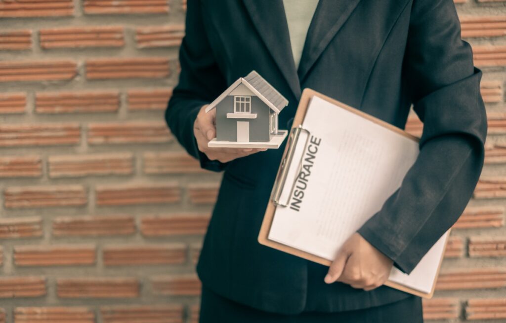 Une personne tenant une maquette de maison