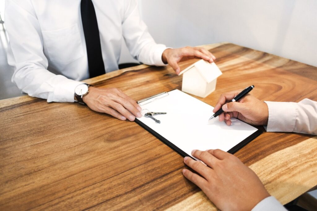 Un agent immobilier et un client qui signe un contrat