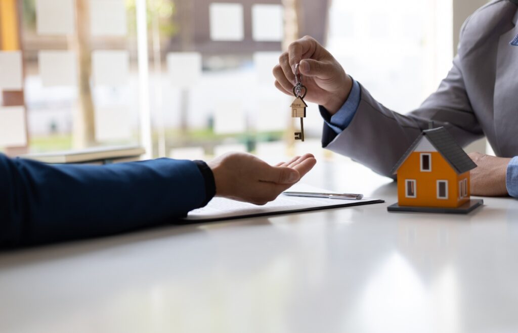 Un agent immobilier qui donne une clé de maison à son client