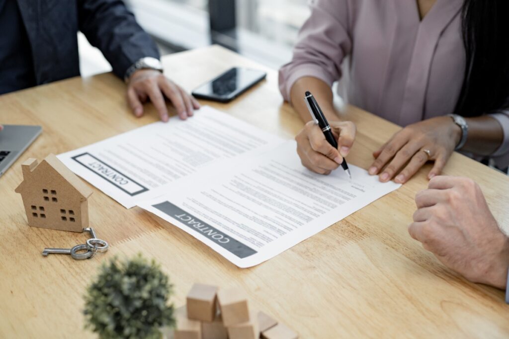 Une personne qui signe un contrat sur la table