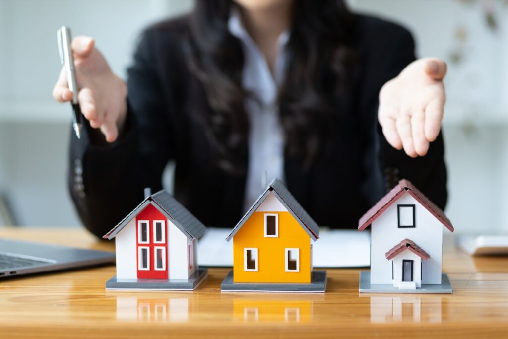 Un agent immobilier qui présente des modèles de maison