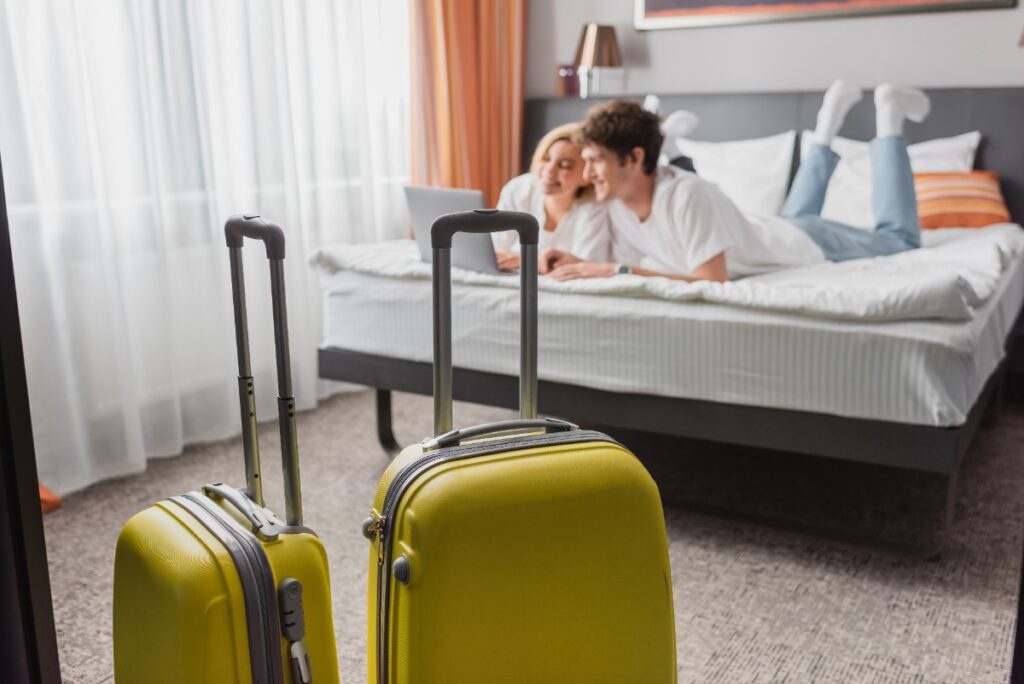 Un couple allongé sur le lit dans un appartement avec leur valise