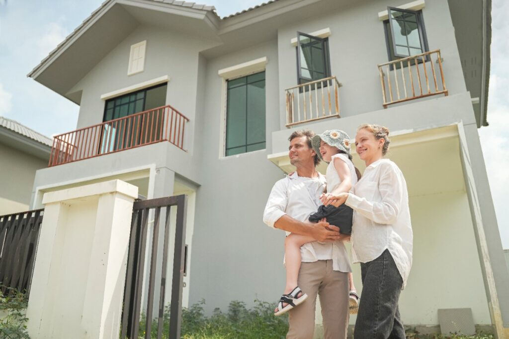 Une famille s'embrassant devant leur nouvelle maison