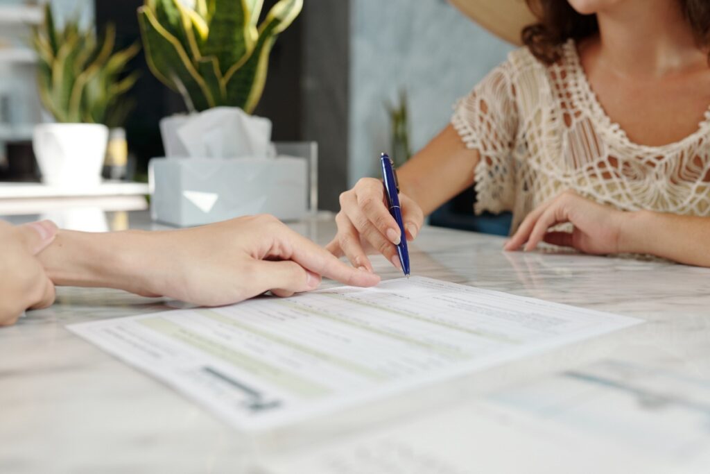 Une personne signant un contrat sur table