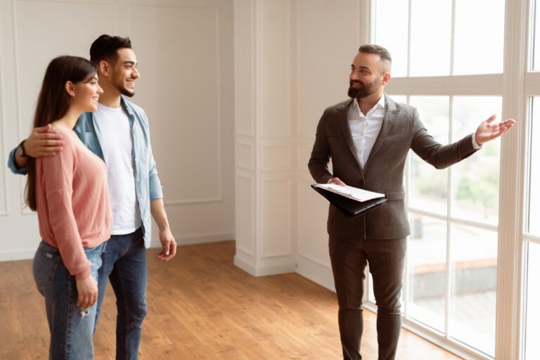 Un agent immobilier montrant une propriété à un couple