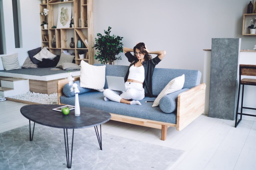 Une femme assise et travaille sur un canapé