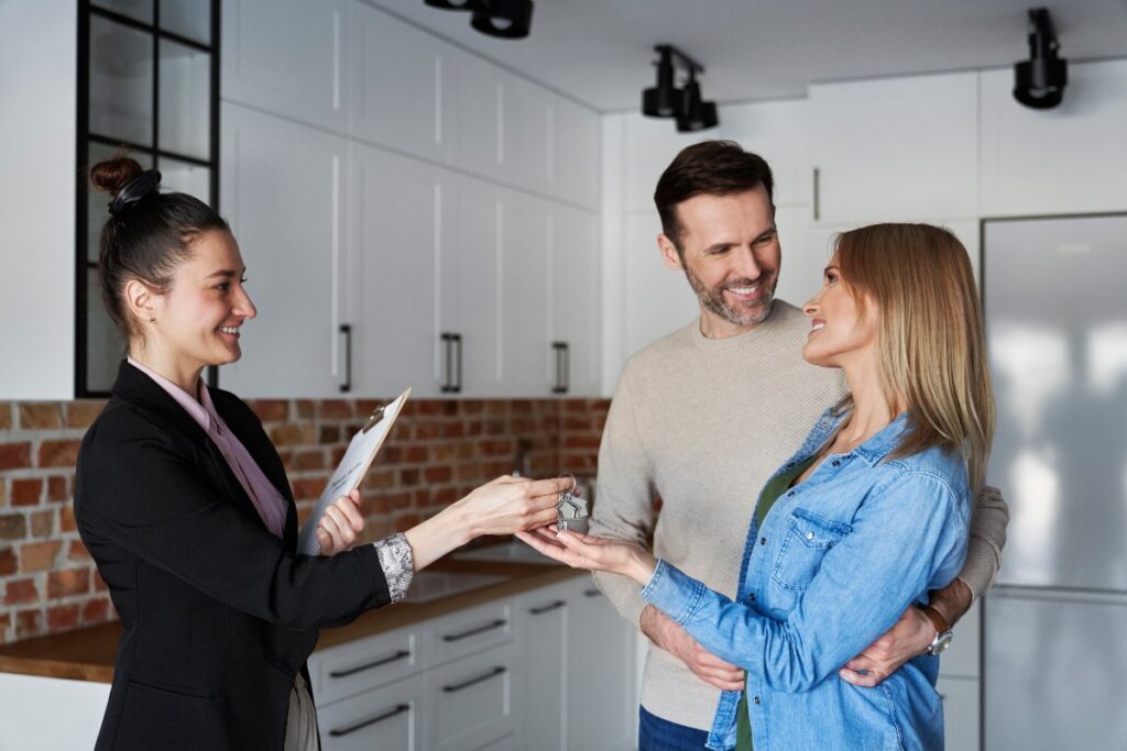 Une femme donnant une clé de maison à un couple