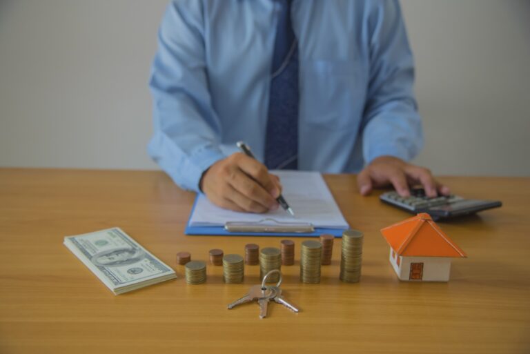 Un homme qui signe un contrat immobilier sur la table avec des clés