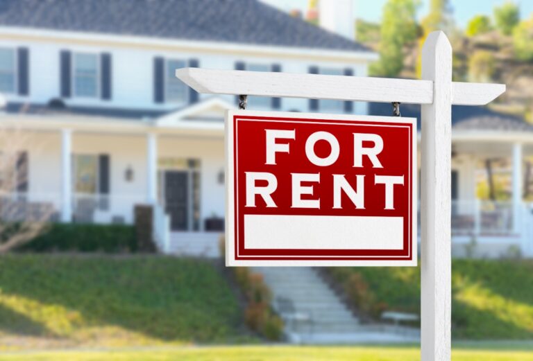 Un panneau immobilier à louer devant une maison