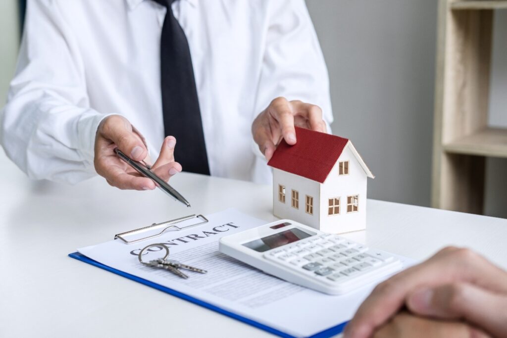 Une personne qui discute avec un agent et signe un contrat immobilier