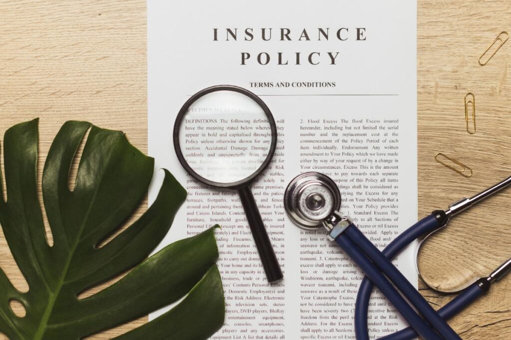 Un stéthoscope avec un dossier d'assurance sur la table