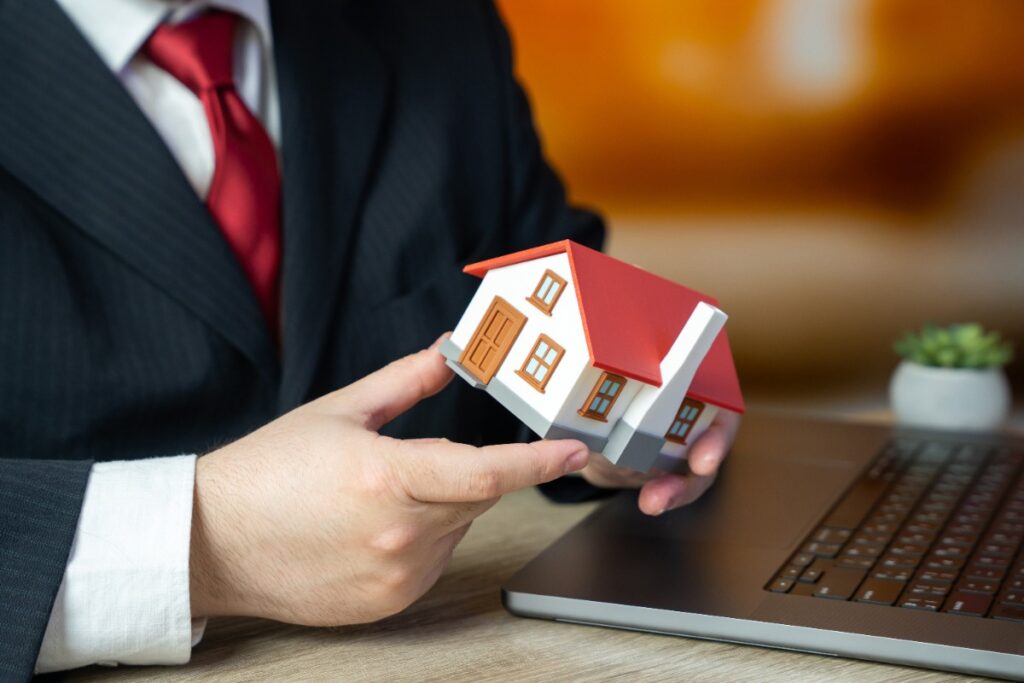 Un homme tenant une petite maison